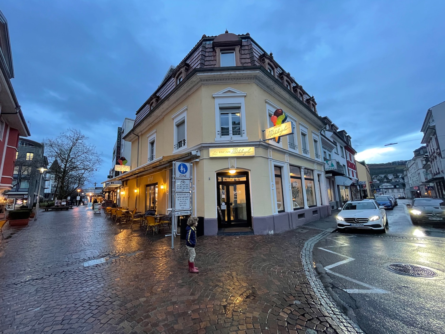 a building with a corner of it and cars parked on the side of it