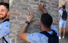 a man writing on a brick wall