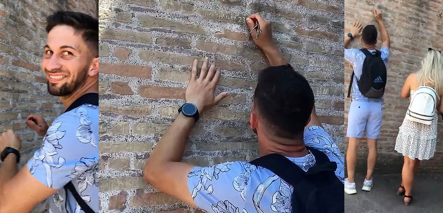 a man writing on a brick wall