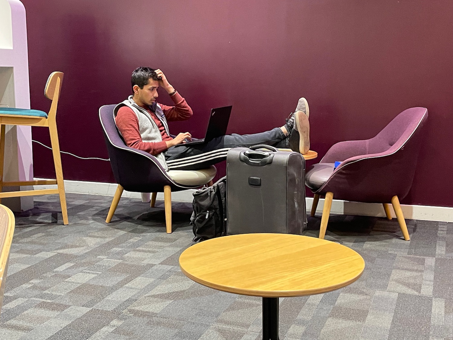 a man sitting in chairs with his legs on a laptop