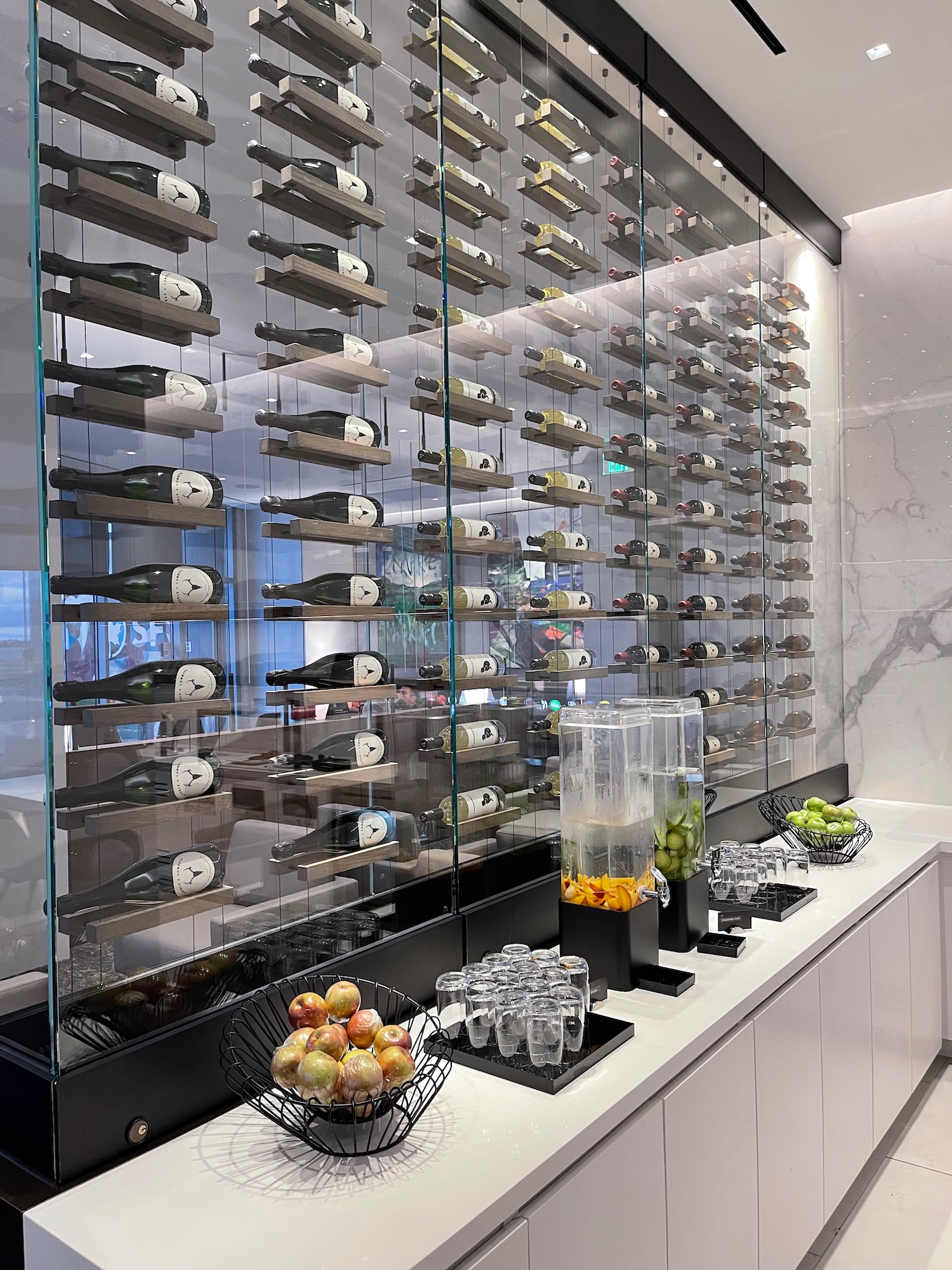 a glass wall with bottles of wine and fruit