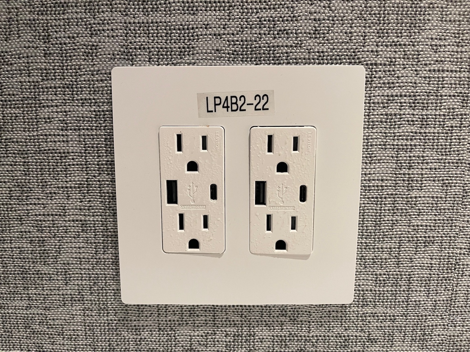 a white electrical outlet on a gray surface