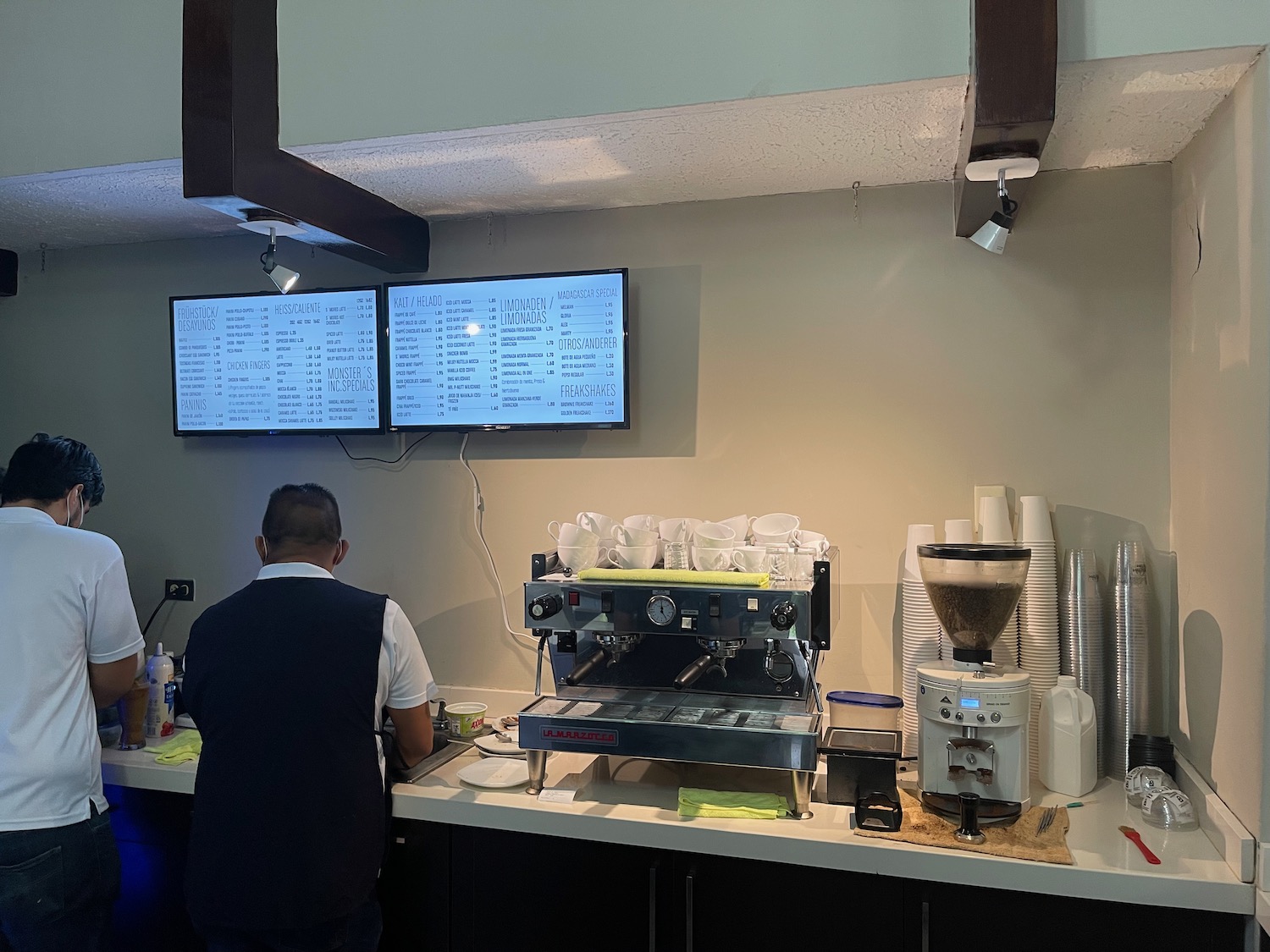 a man standing at a counter with a machine and a screen