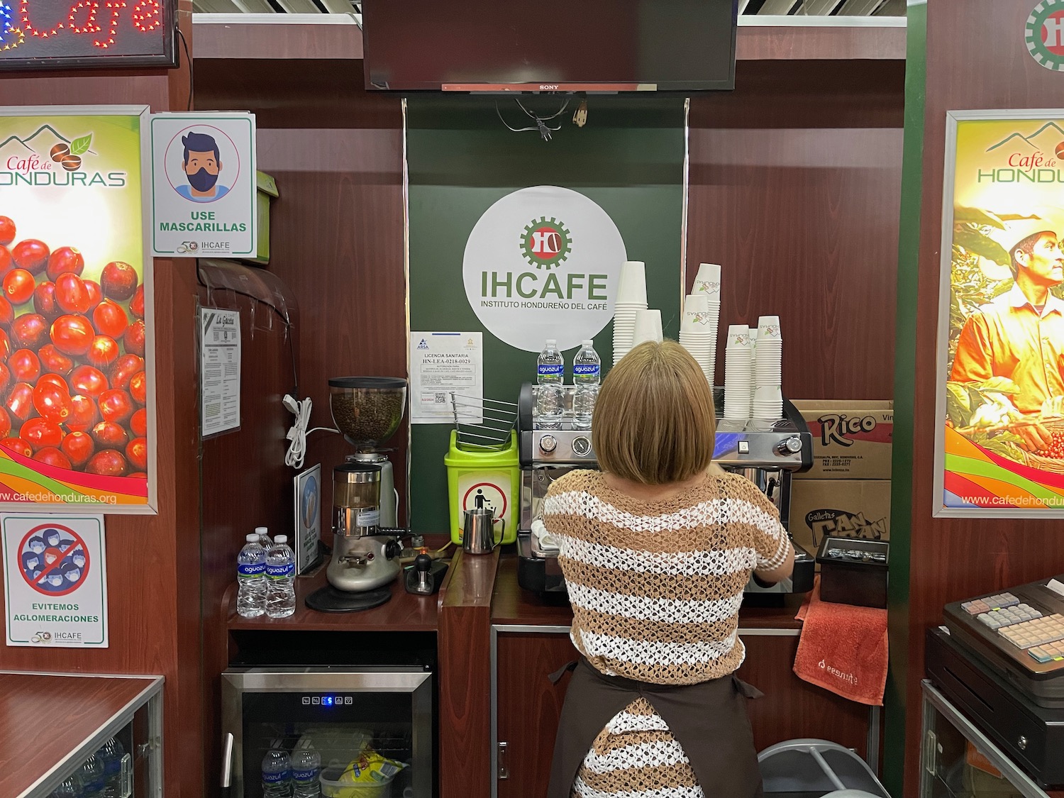 a woman standing behind a coffee machine