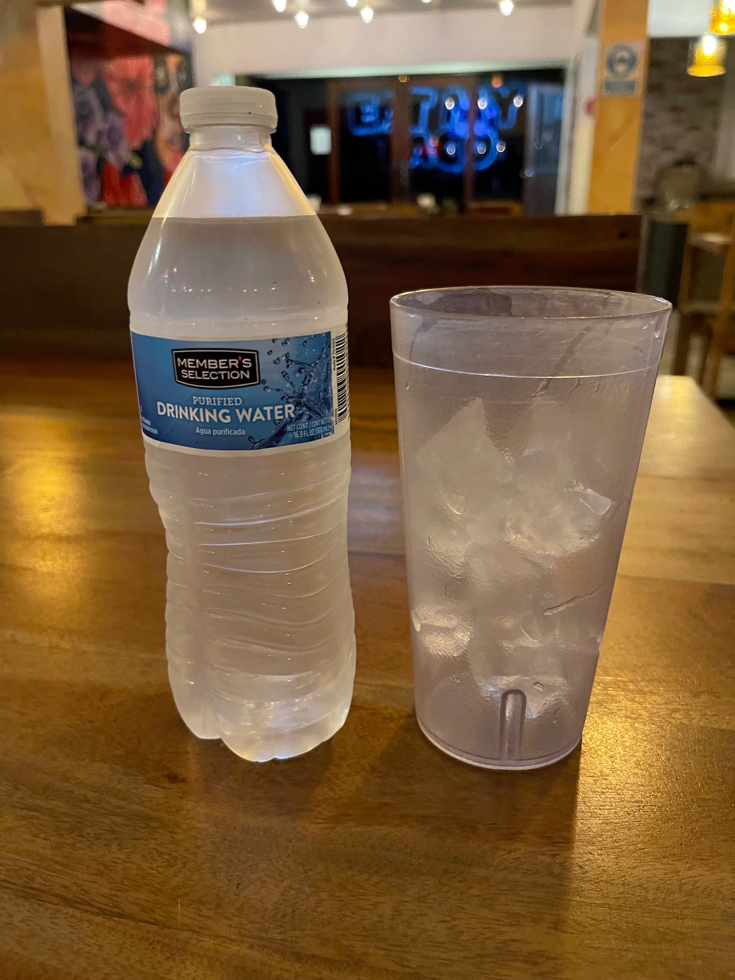 a bottle of water next to a glass of ice