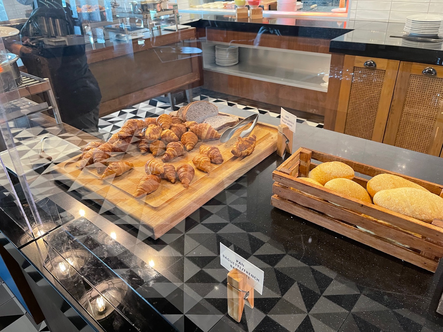 a display case with bread and croissants