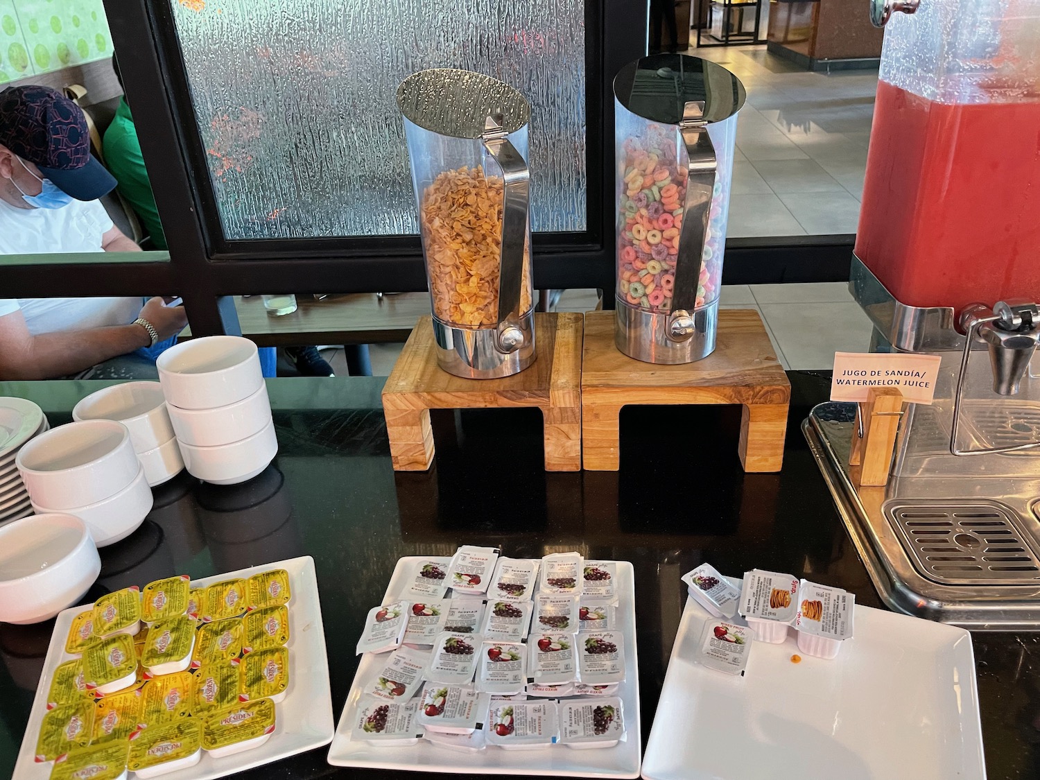 a table with food containers and a drink dispenser