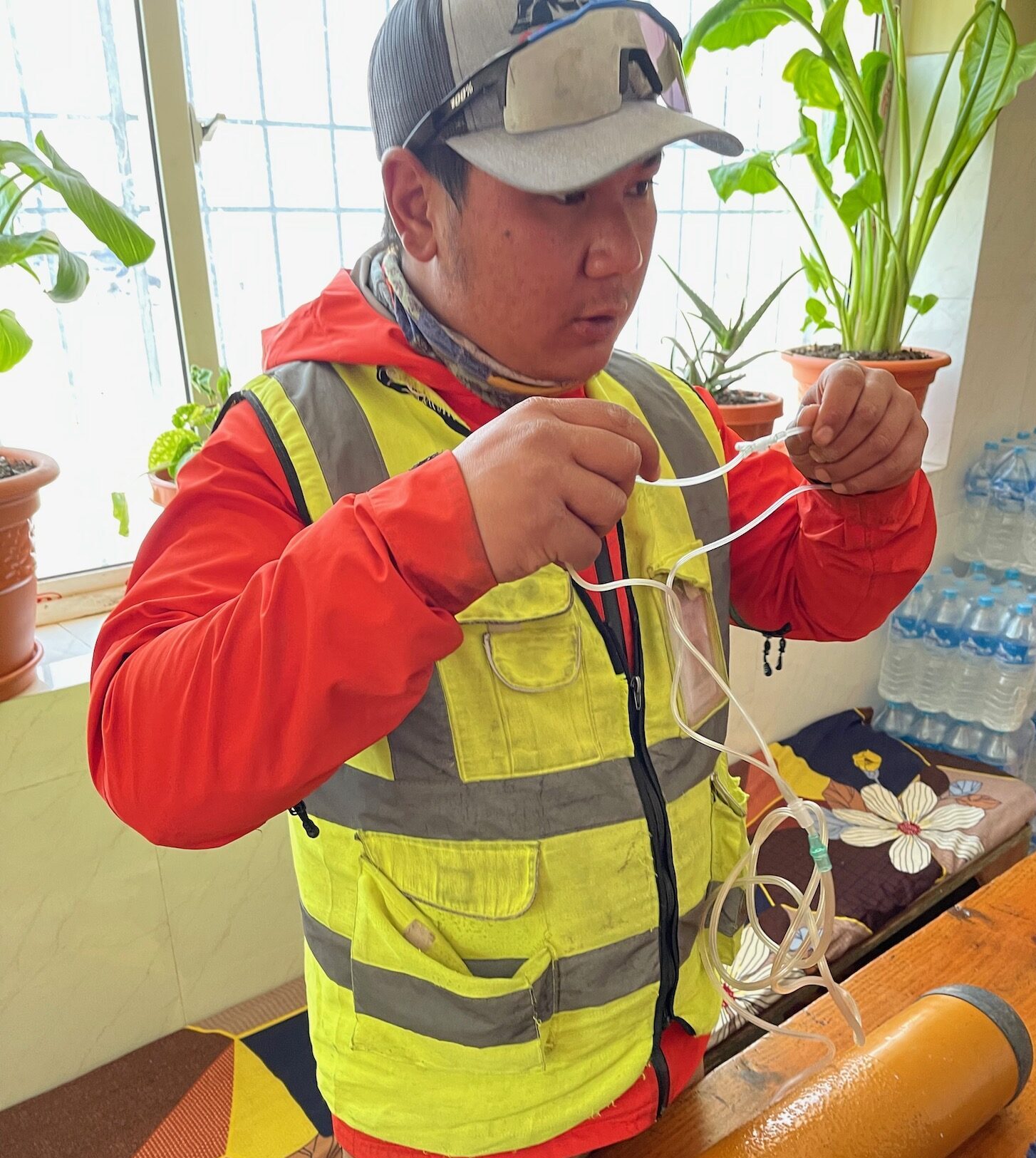 a man in a yellow vest holding wires