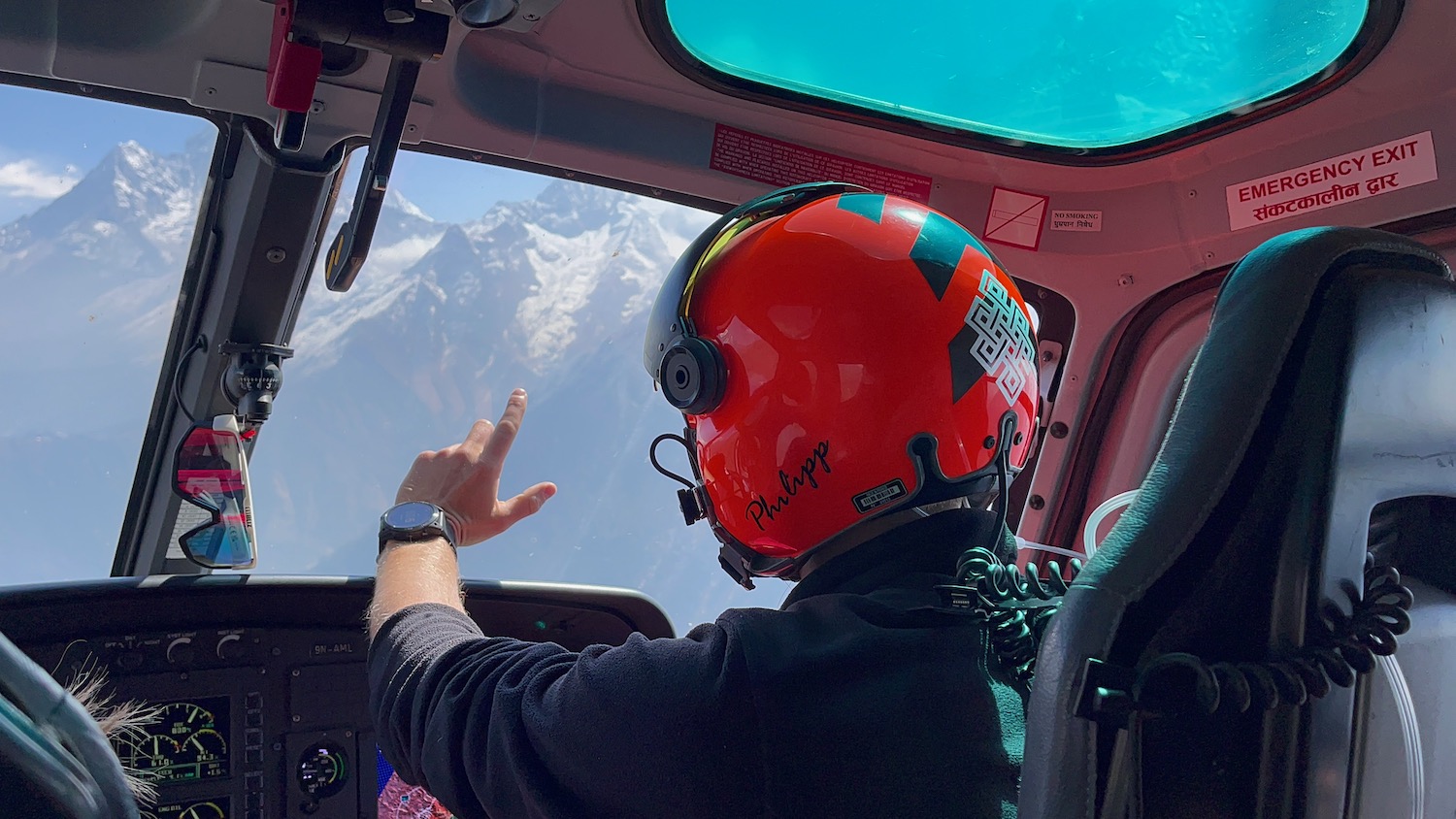 a person in a helmet pointing out of a window