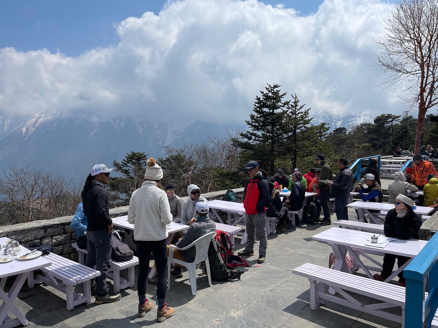 a group of people sitting at tables outside