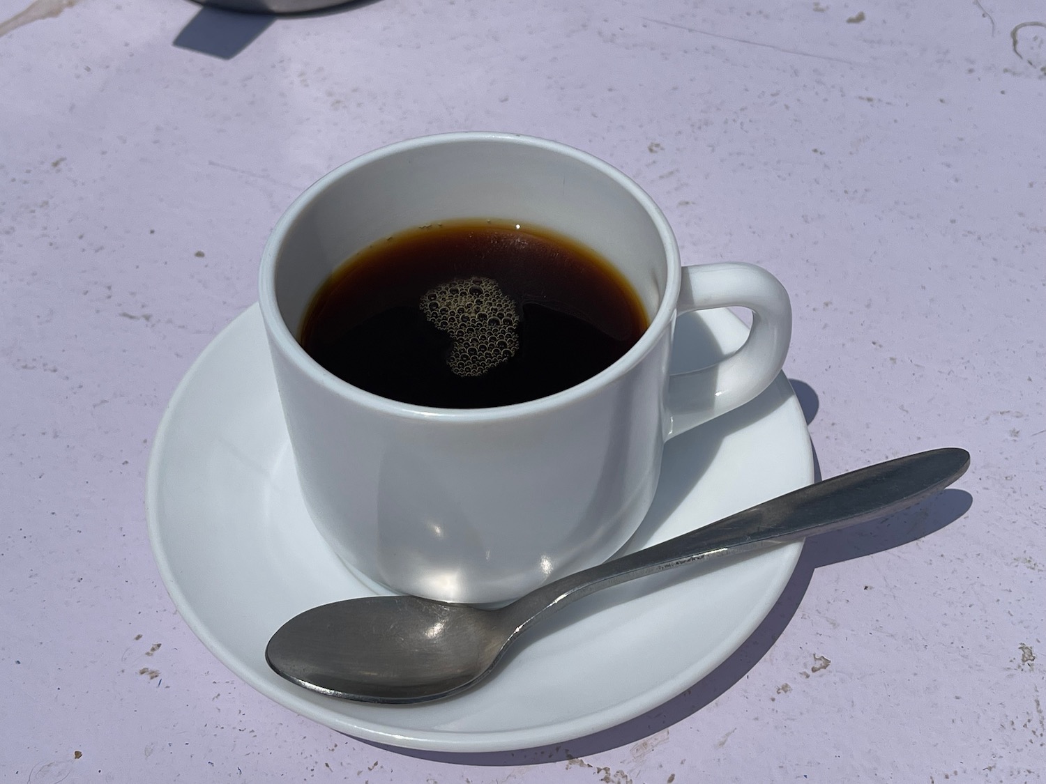 a cup of coffee on a saucer with a spoon