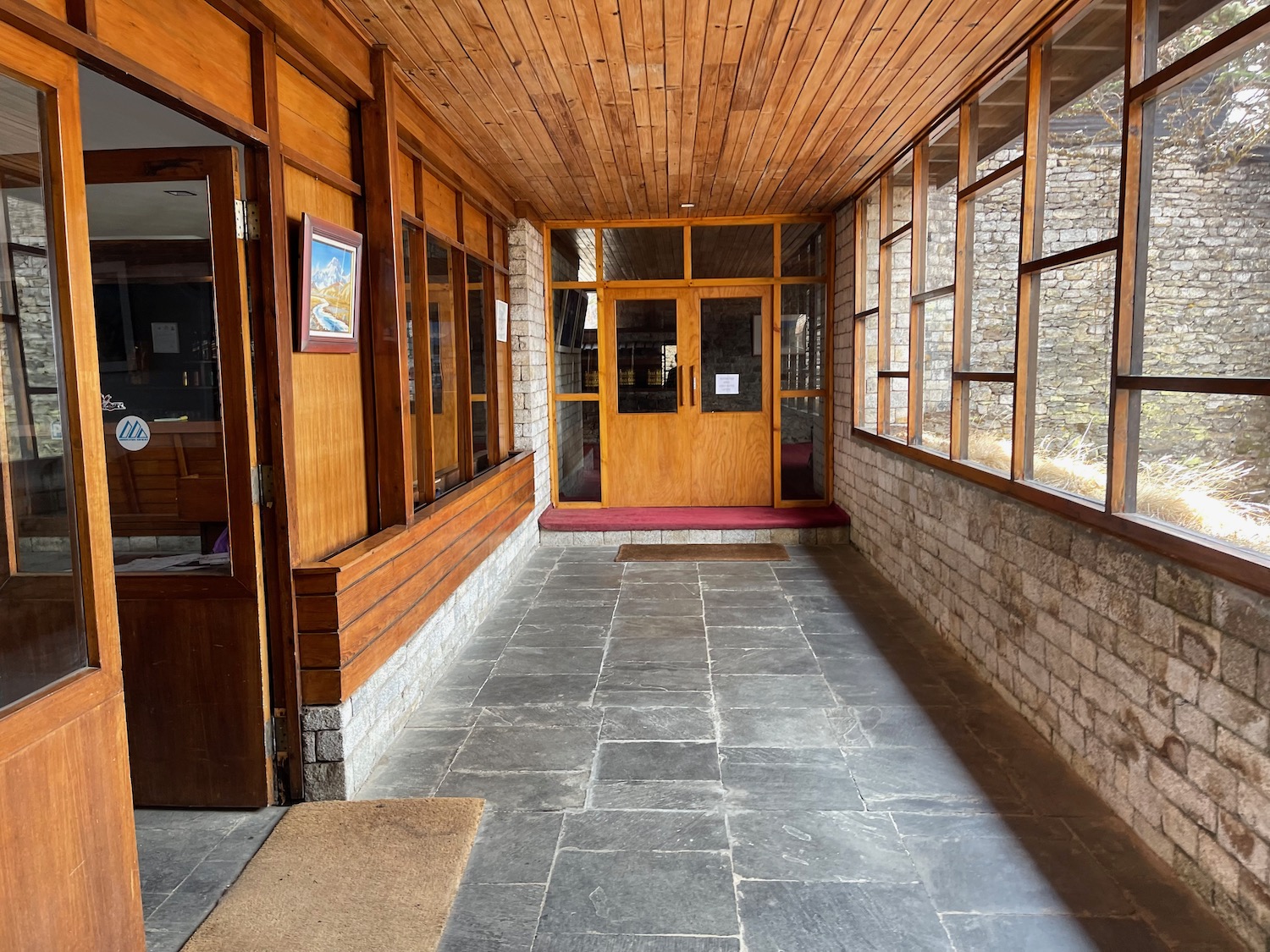 a hallway with a stone walkway and a wood door