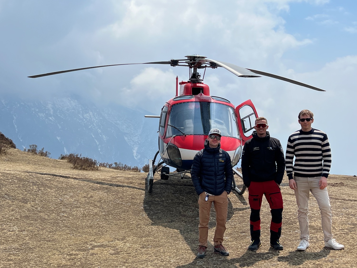 a group of men standing in front of a helicopter