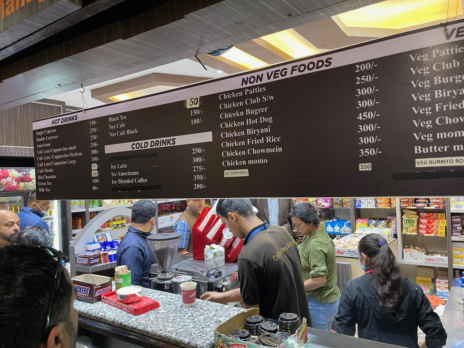 a group of people standing in a food store