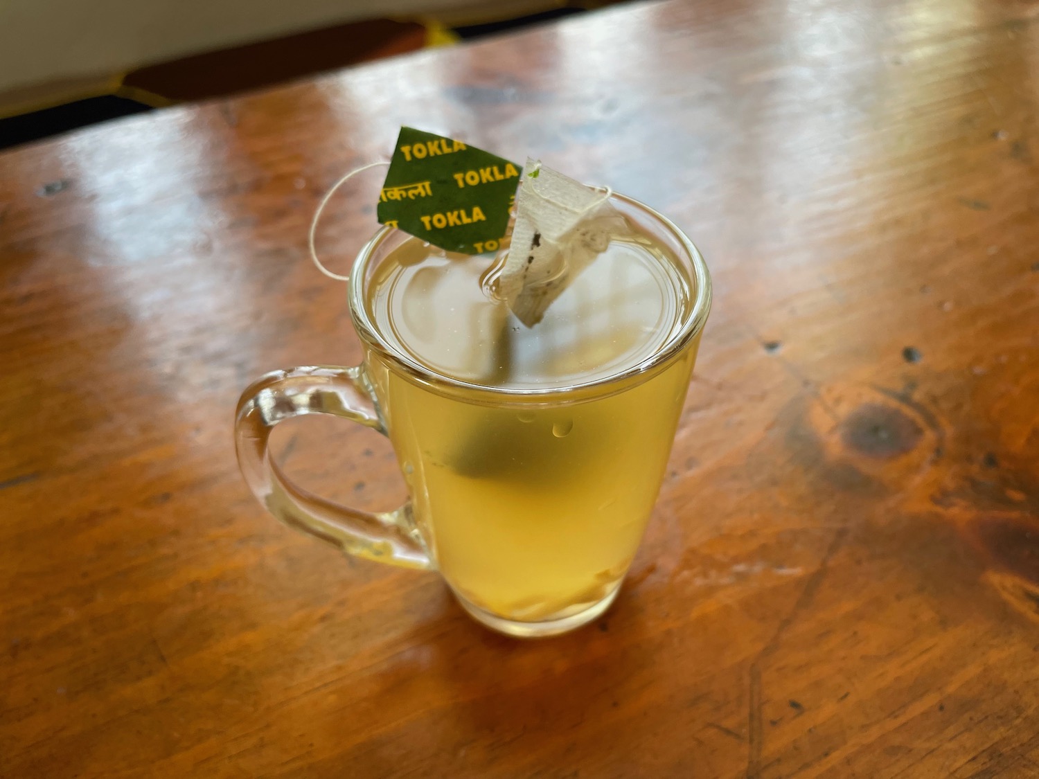 a glass cup of tea with a tea bag on top