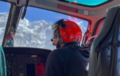 a man in a helmet looking out of a helicopter