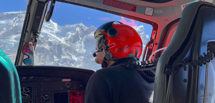 a man in a helmet looking out of a helicopter