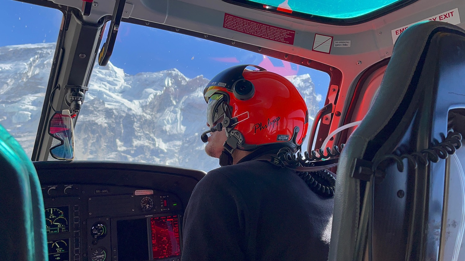 a man in a helmet looking out of a helicopter