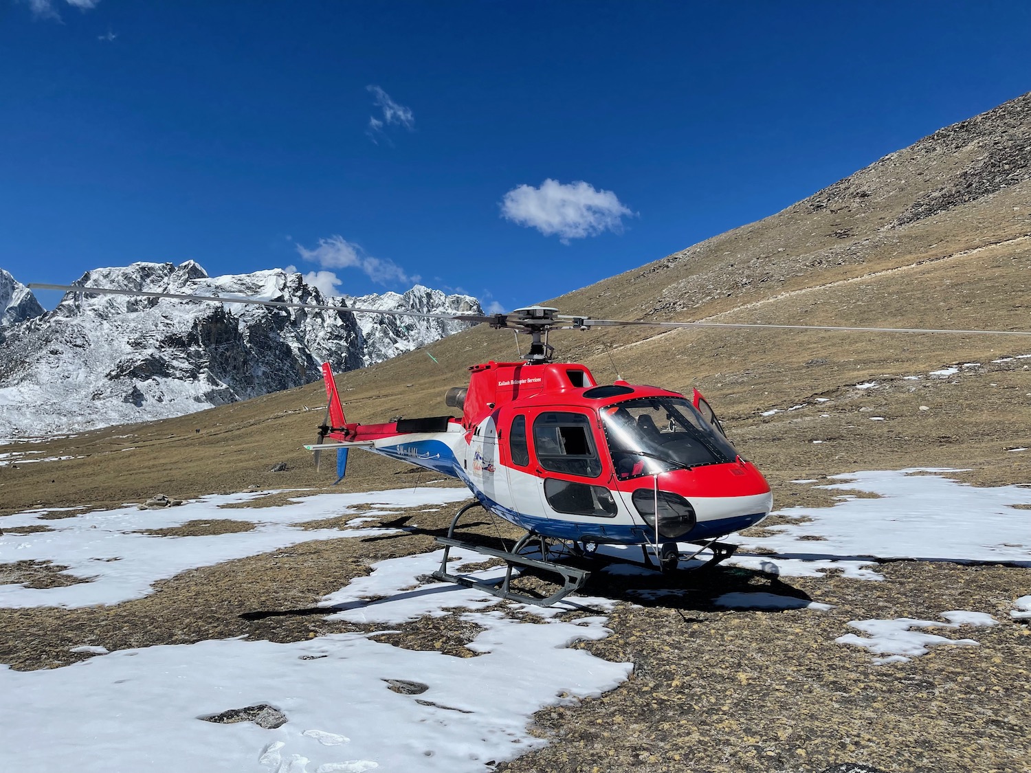 A red and white helicopter on a snowy mountain
