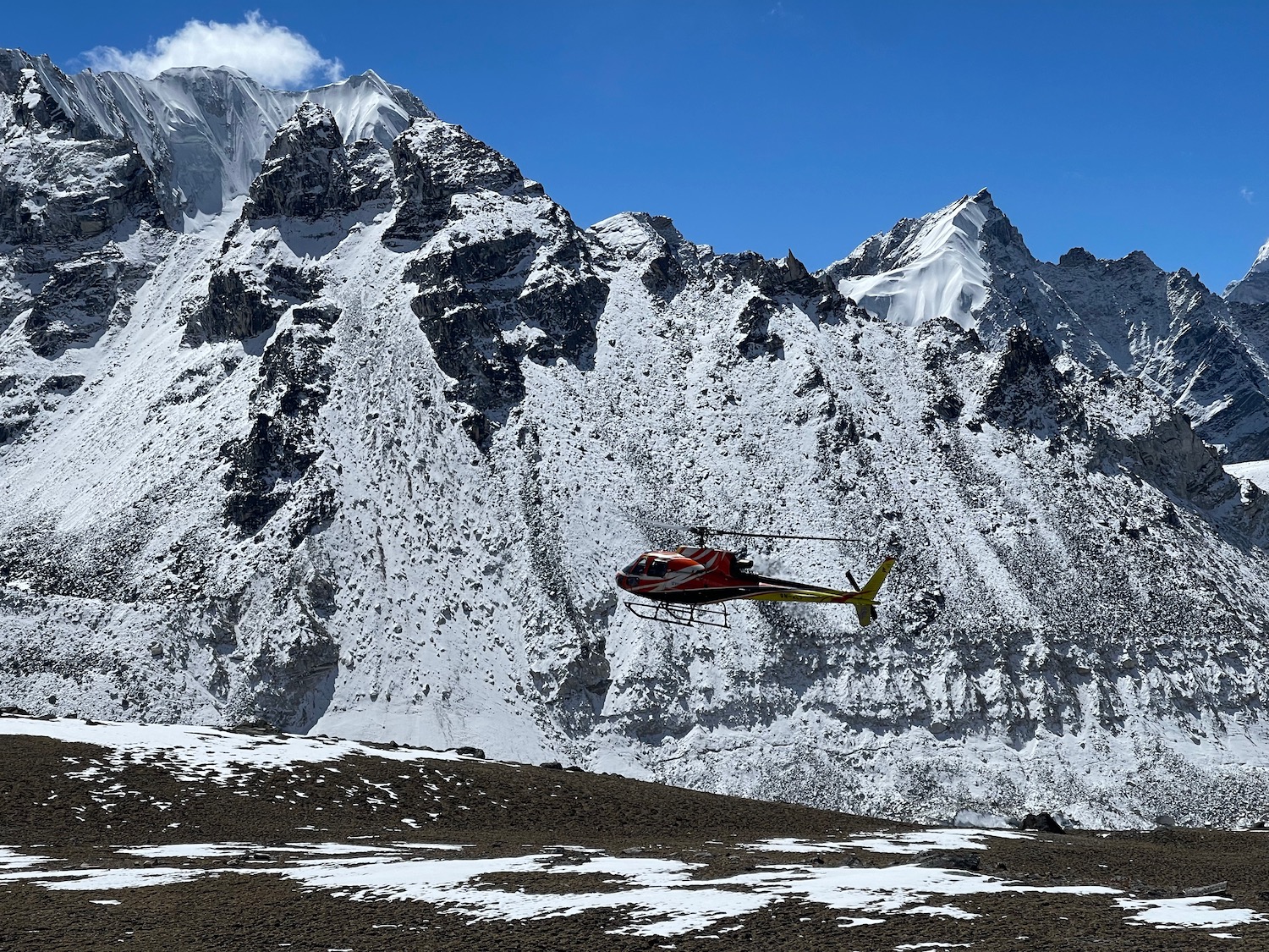 a helicopter flying over a snowy mountain