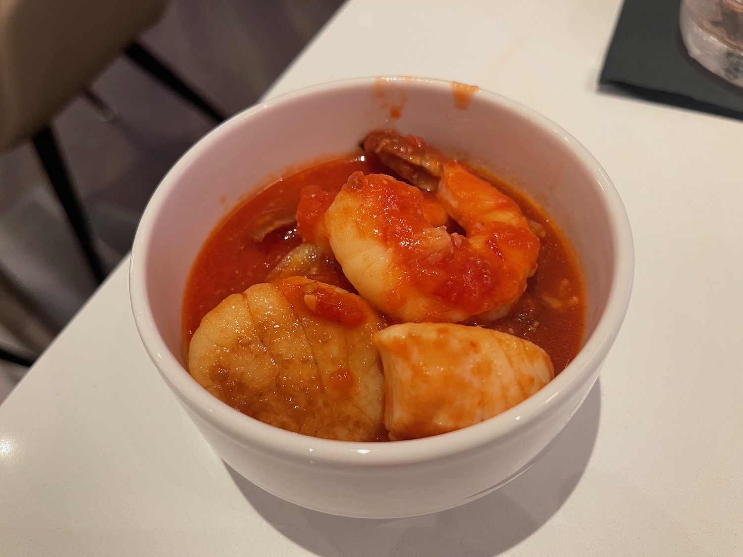 a bowl of soup with shrimp and scallops