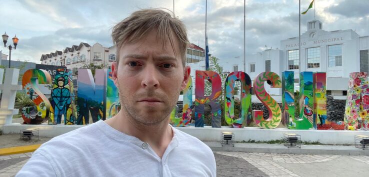 a man taking a selfie in front of a sign