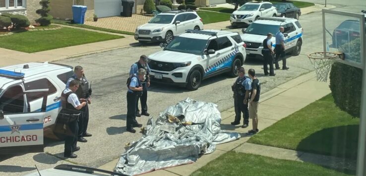 police officers standing around a body of a man