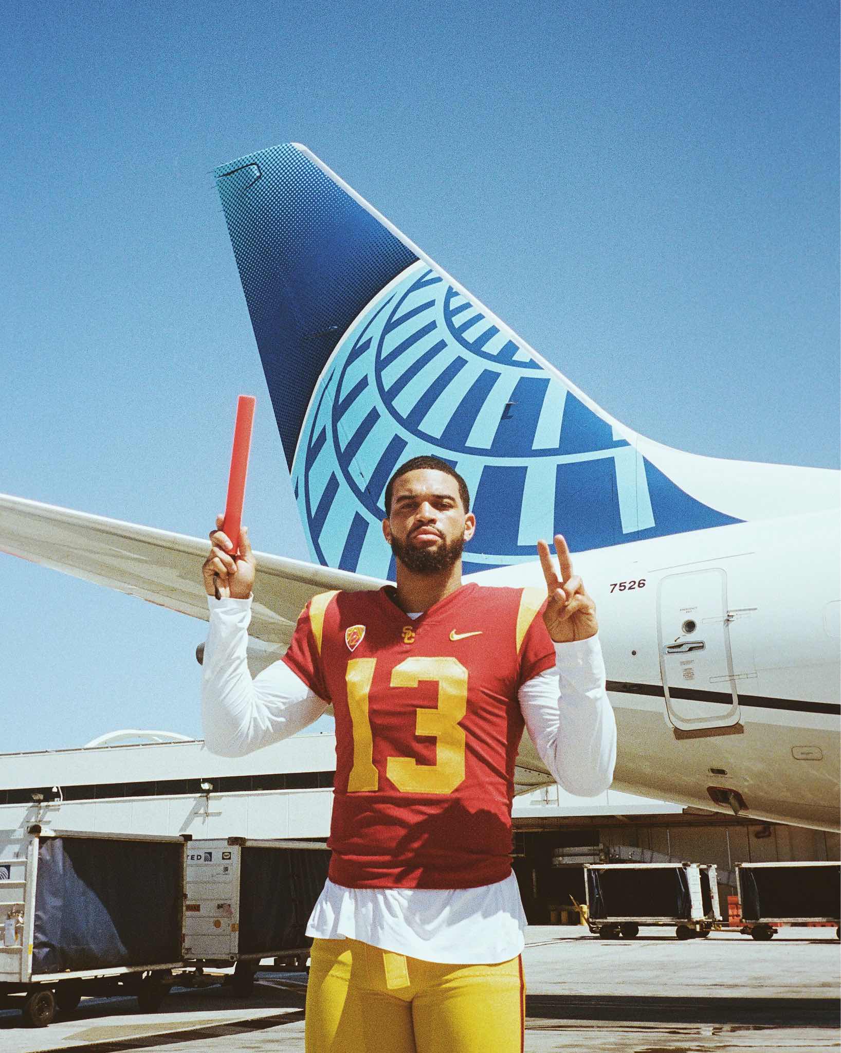 a man holding a red object in front of a plane