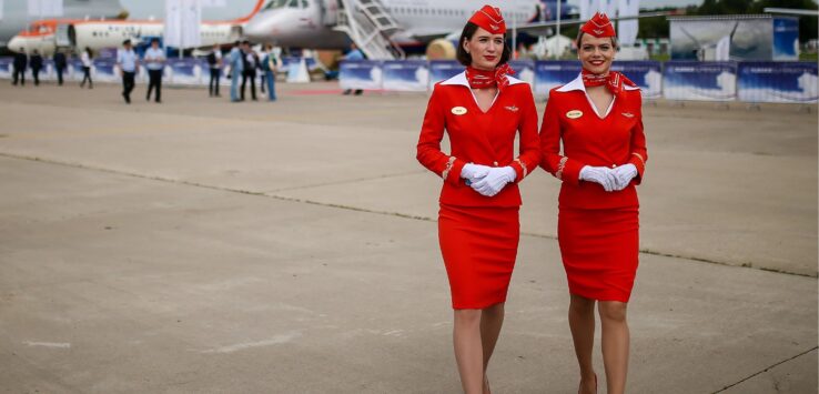 two women wearing red uniforms and white gloves