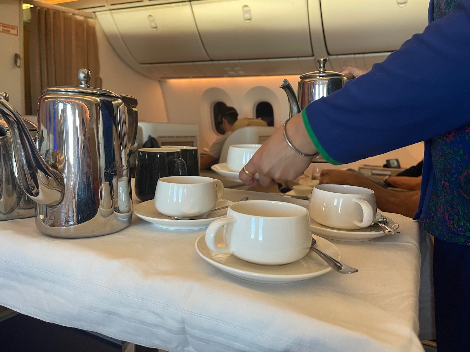 a person pouring tea into cups on a table