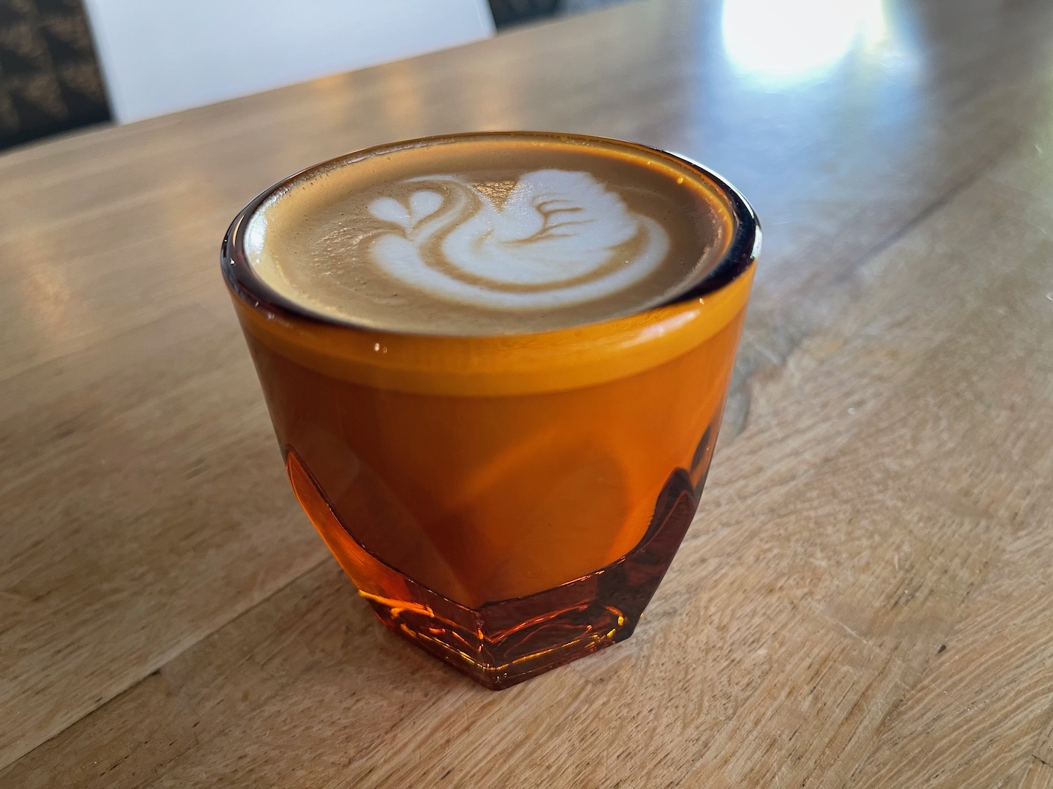 a glass of coffee with a foam in it