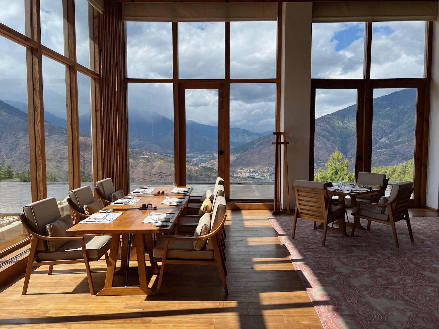 a room with a table and chairs and a view of the mountains