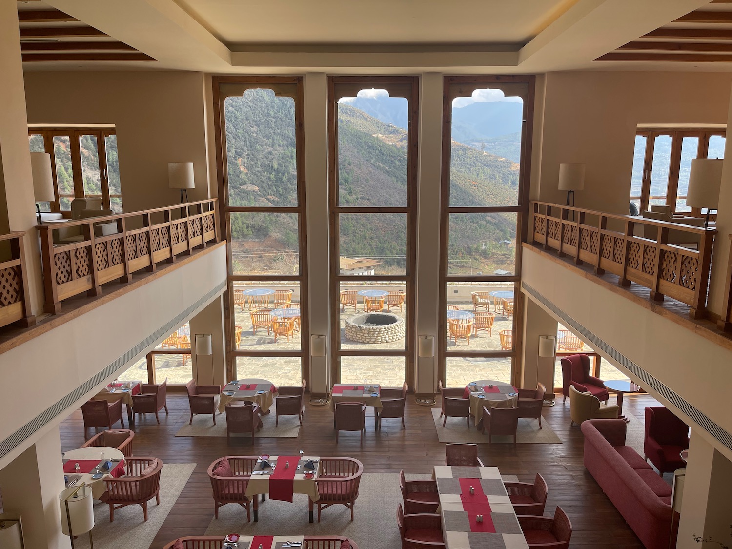 a room with tables and chairs and a view of the mountains