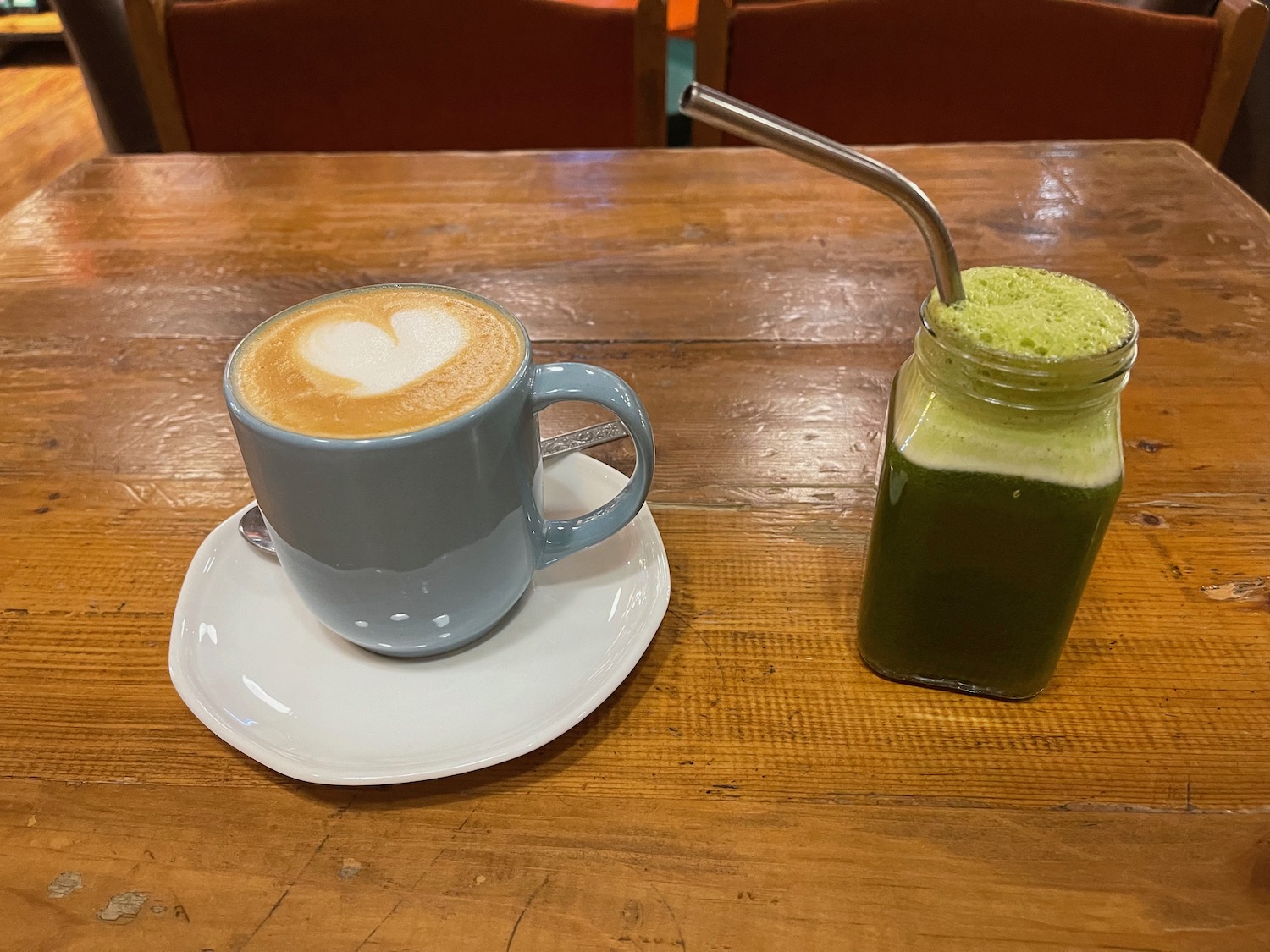 a cup of coffee and a green smoothie on a table