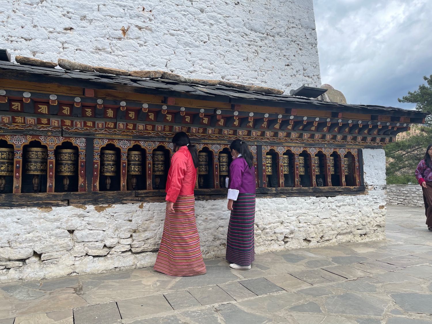 two women in traditional clothing standing in front of a building