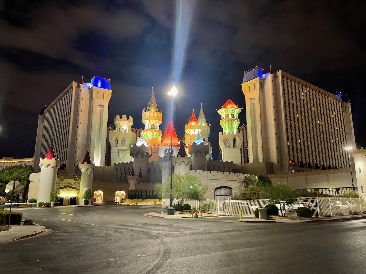 a large building with towers and lights with Excalibur Hotel and Casino in the background
