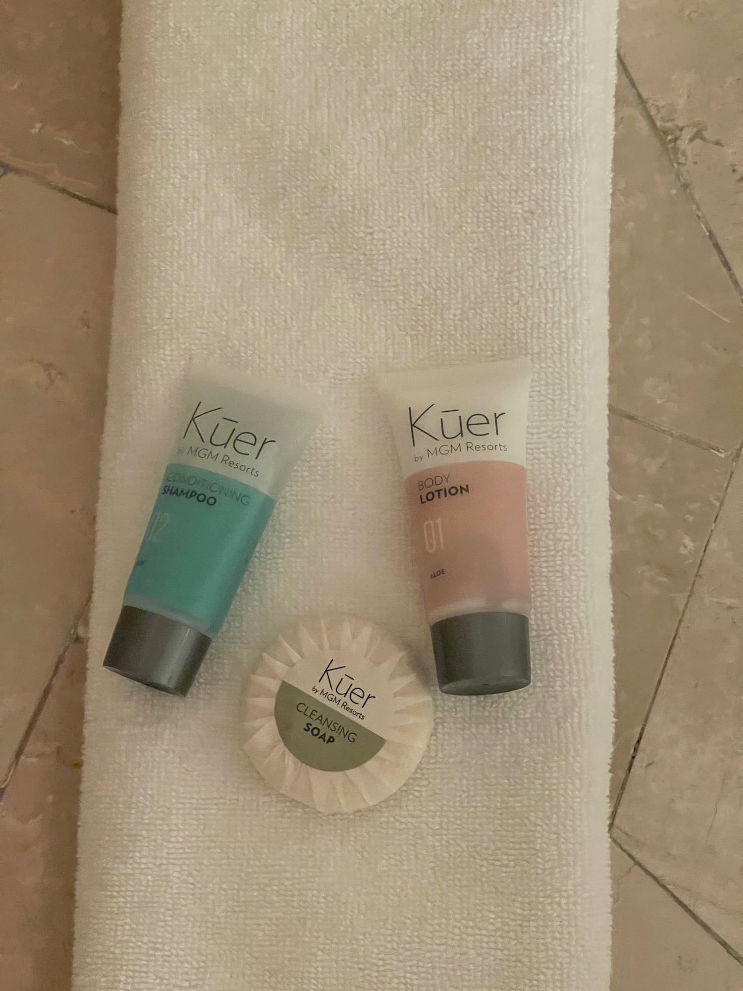 a group of small bottles of shampoo and soap on a towel