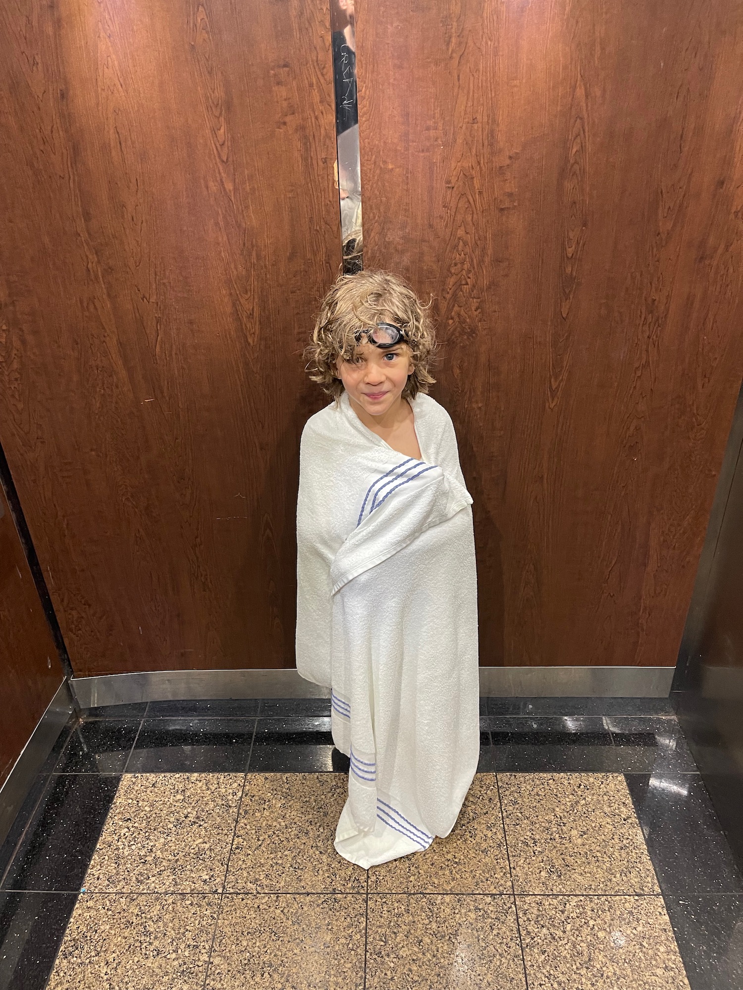 a child wrapped in a towel in an elevator