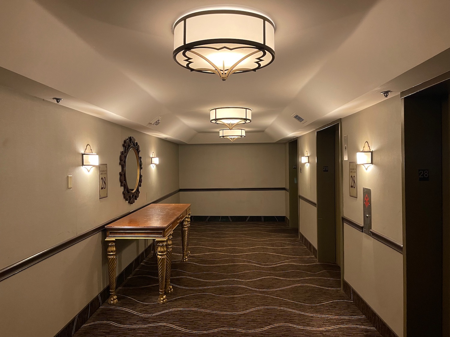 a hallway with a table and lights