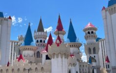 a castle with towers and towers with Excalibur Hotel and Casino in the background