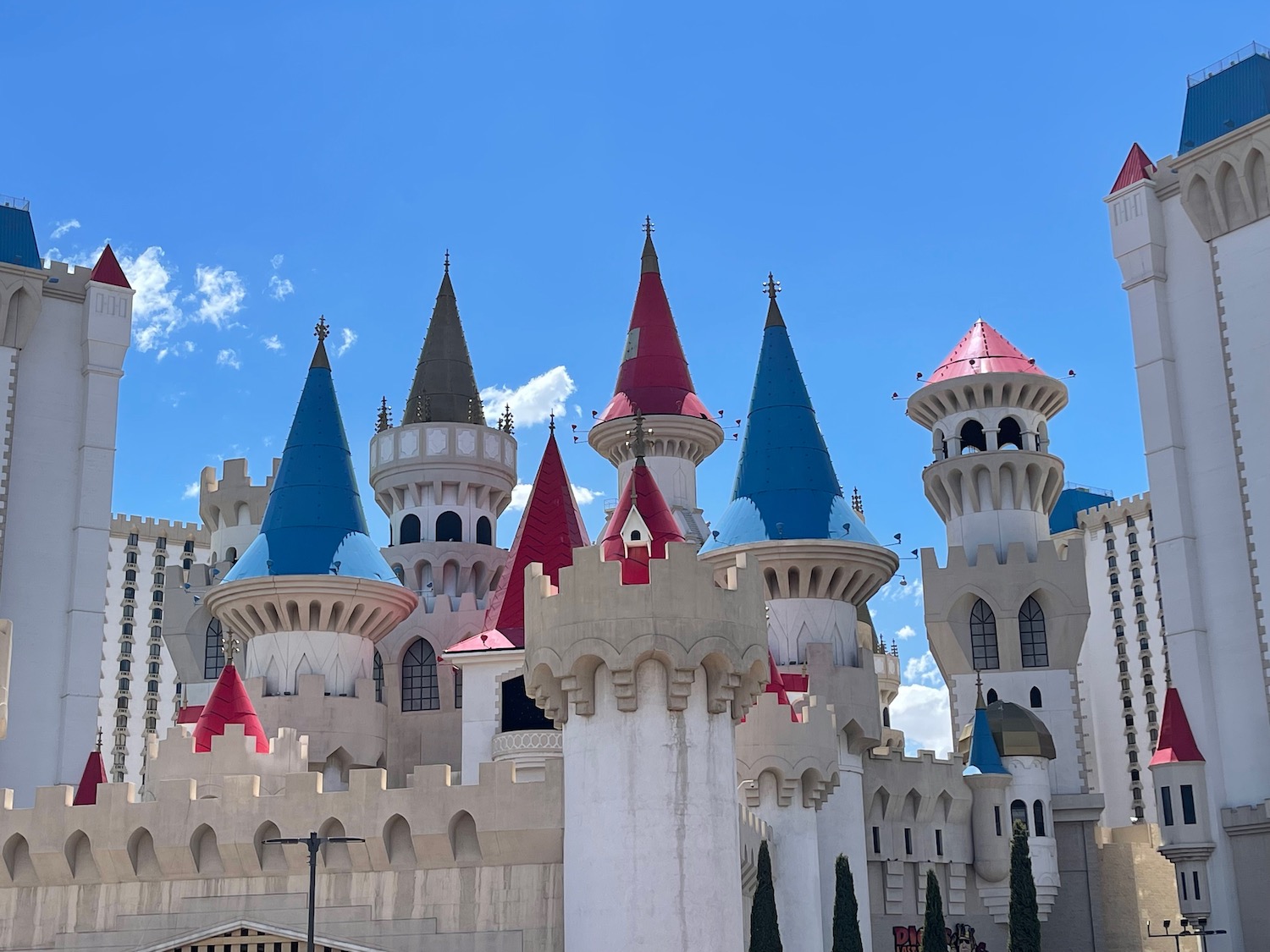 a castle with towers and towers with Excalibur Hotel and Casino in the background