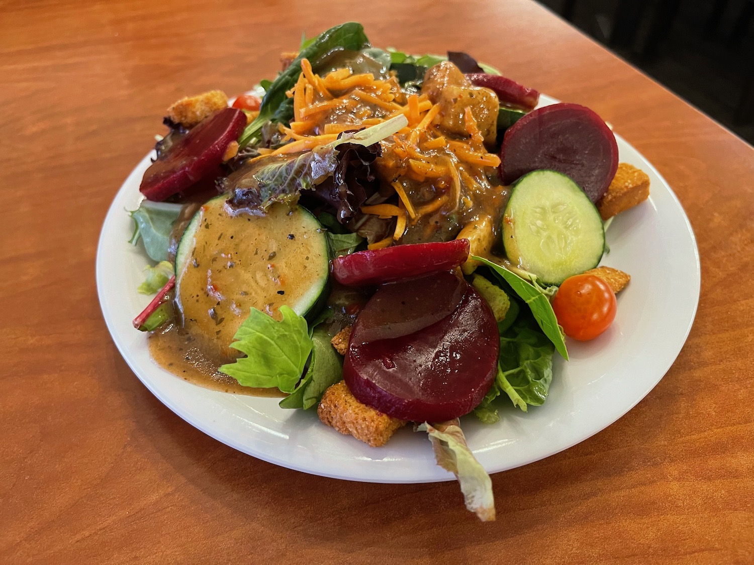 a plate of salad with vegetables and sauce