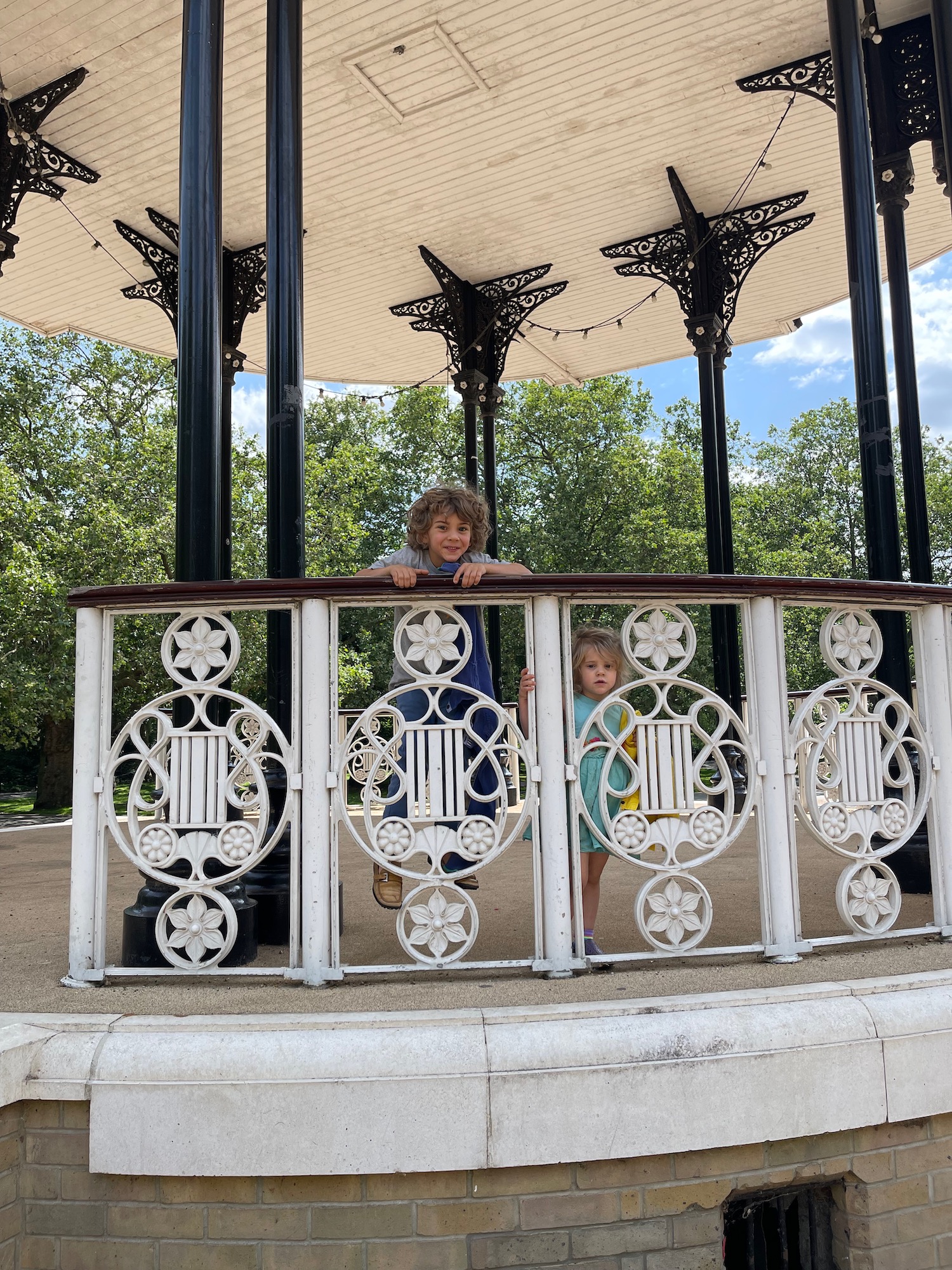 two children standing behind a white railing