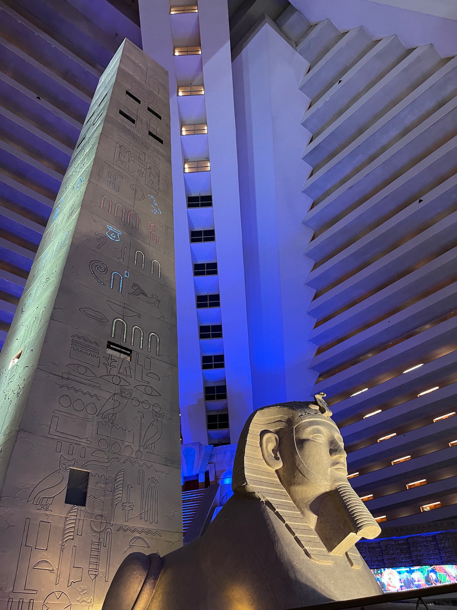 a large stone statue in a room with tall buildings