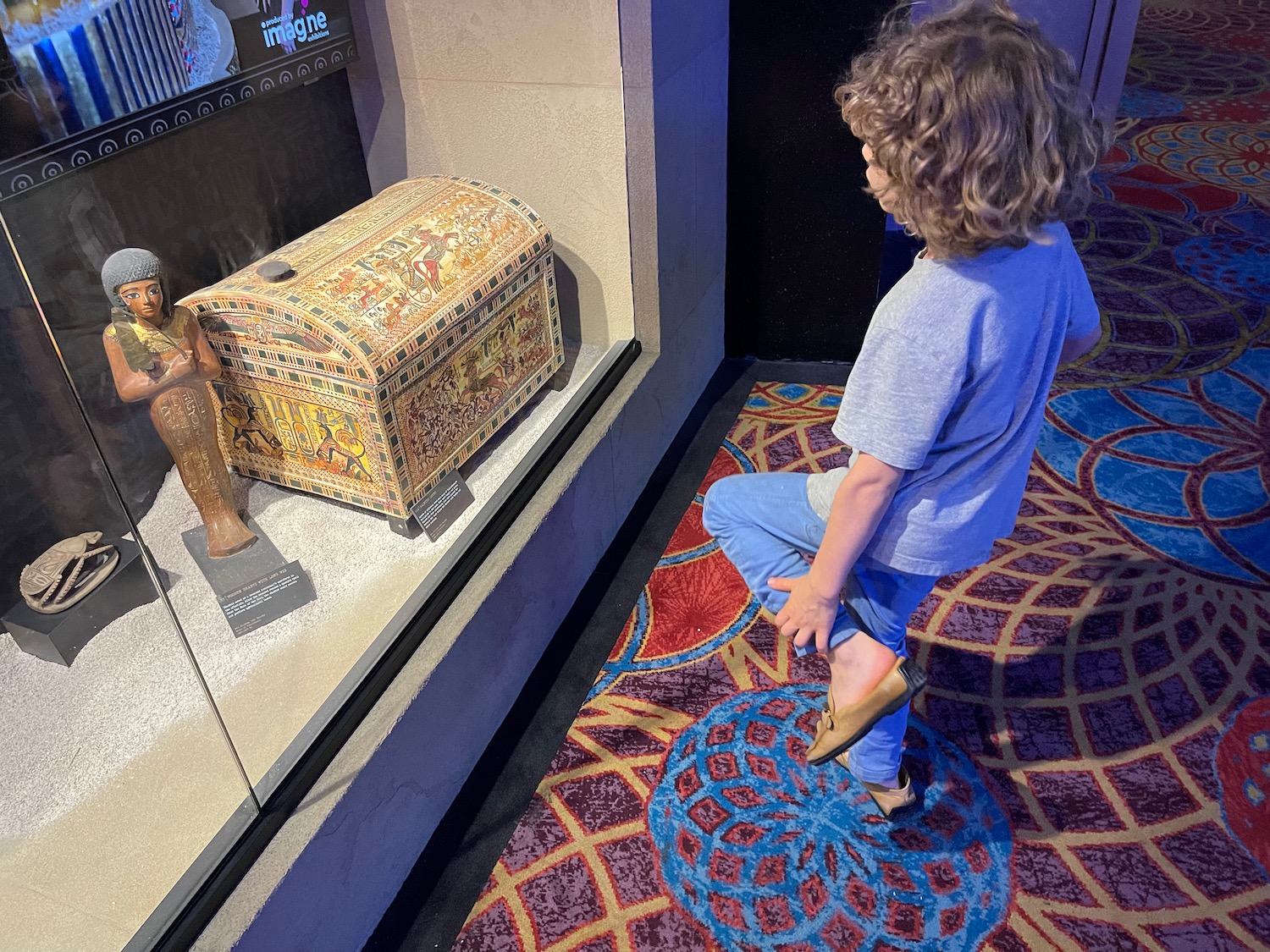 a child standing on one knee in front of a treasure chest