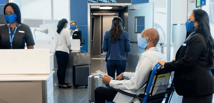 a group of people in a room with luggage