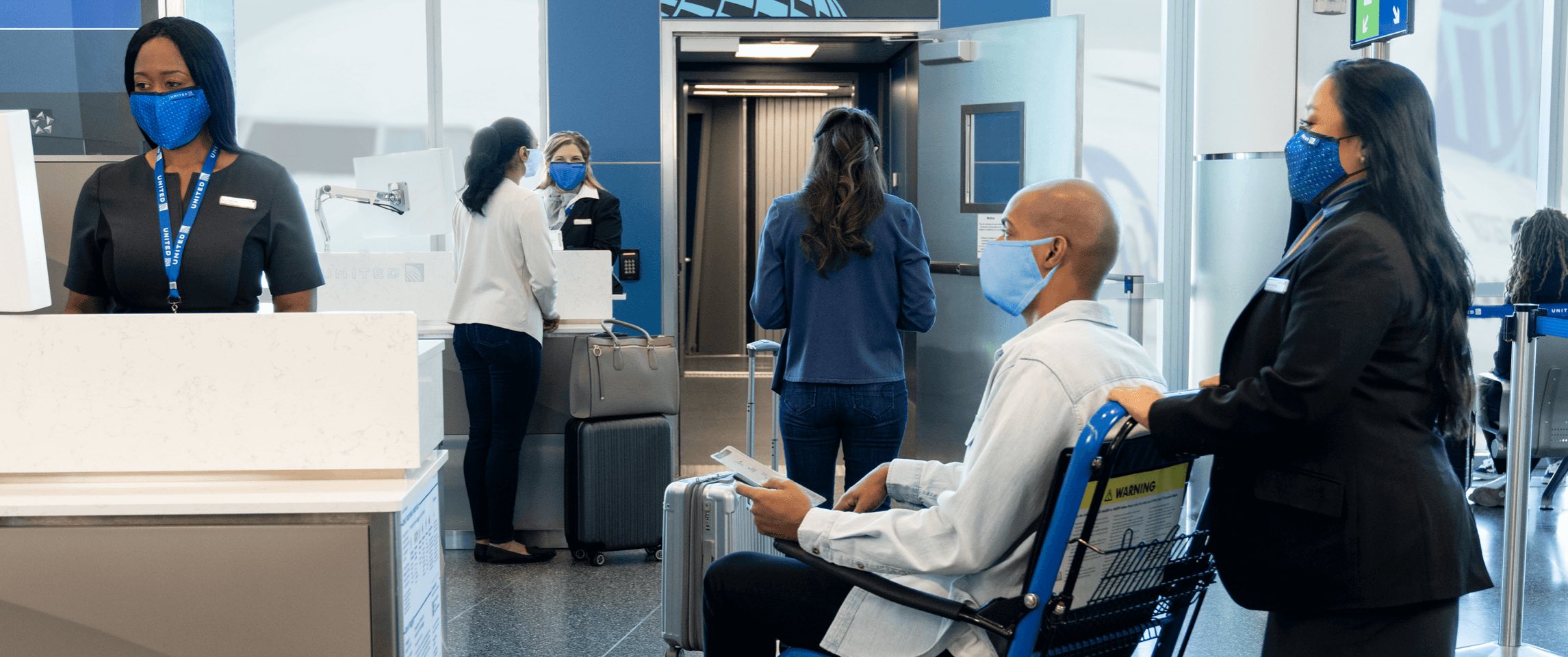 a group of people in a room with luggage