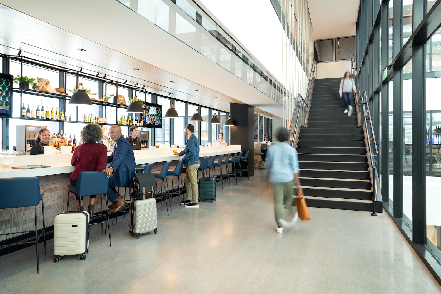 people in a building with a bar and stairs