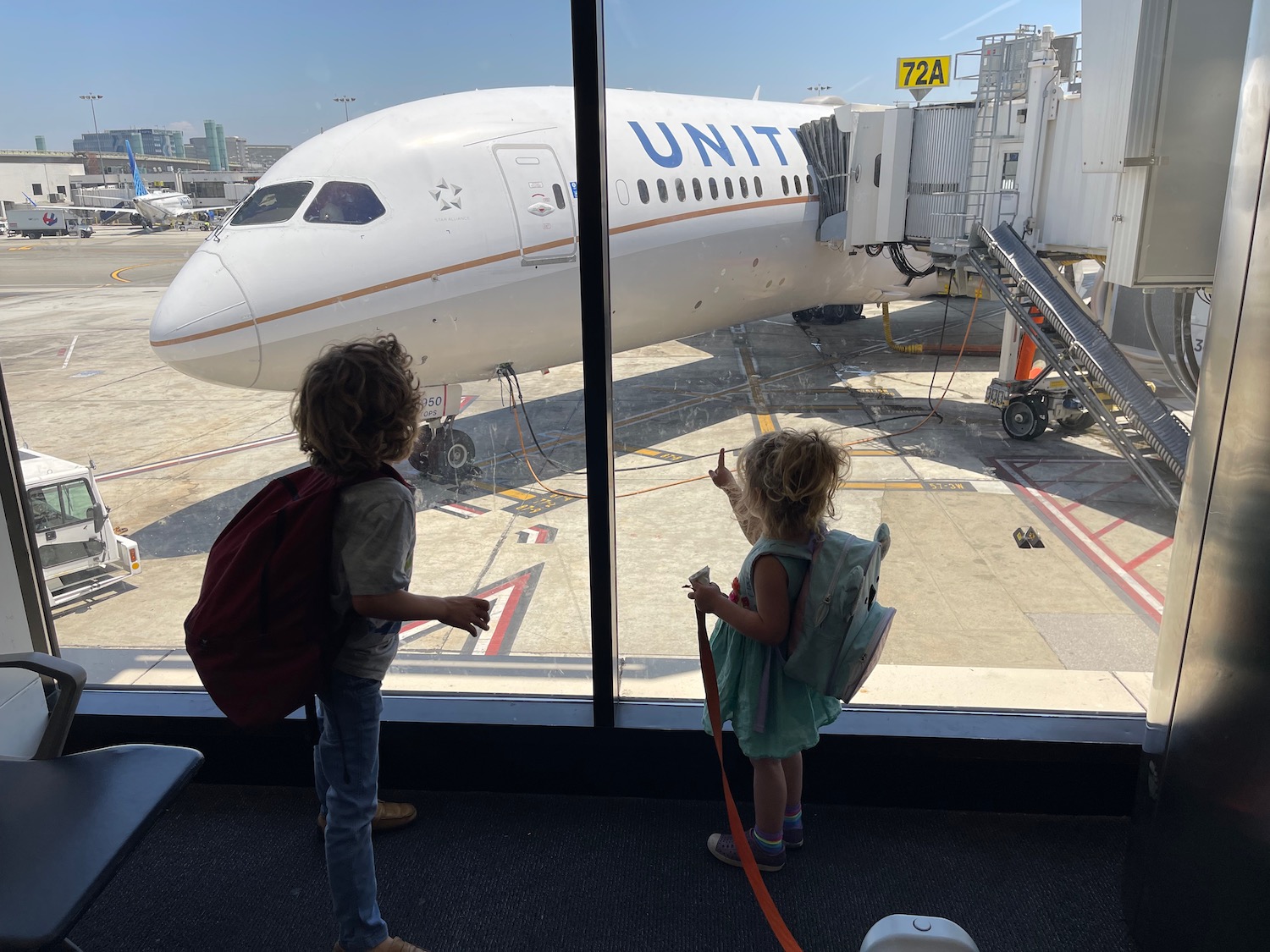 two children looking at an airplane