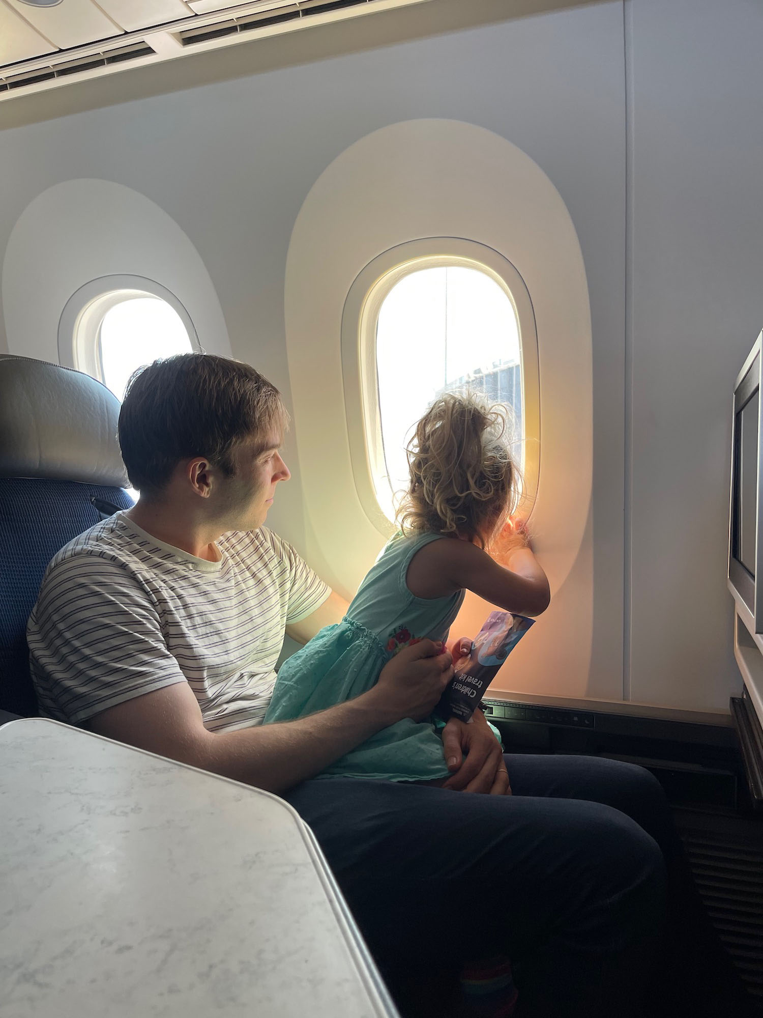 a man and child looking out of an airplane window